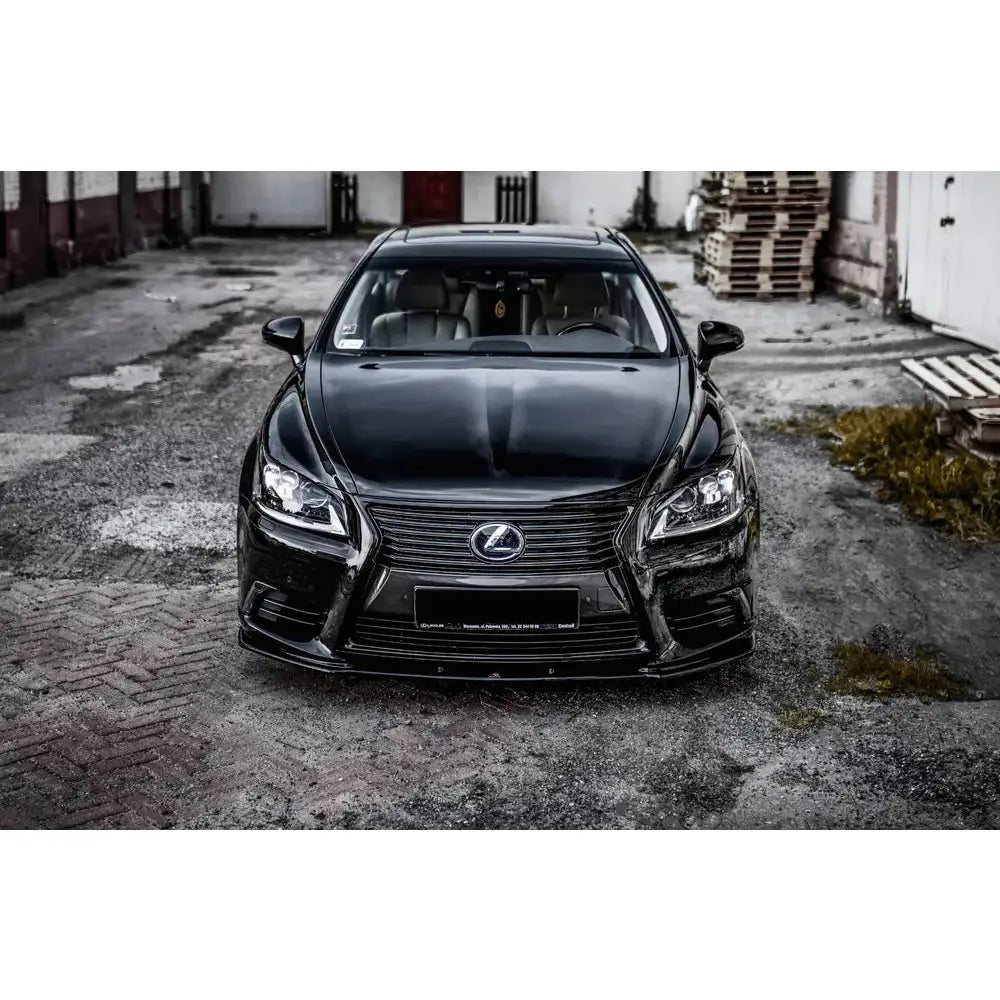 Front splitter på Lexus LS MK4 Facelift med kromgrill og LED-lykter, sett forfra på slitt asfalt.