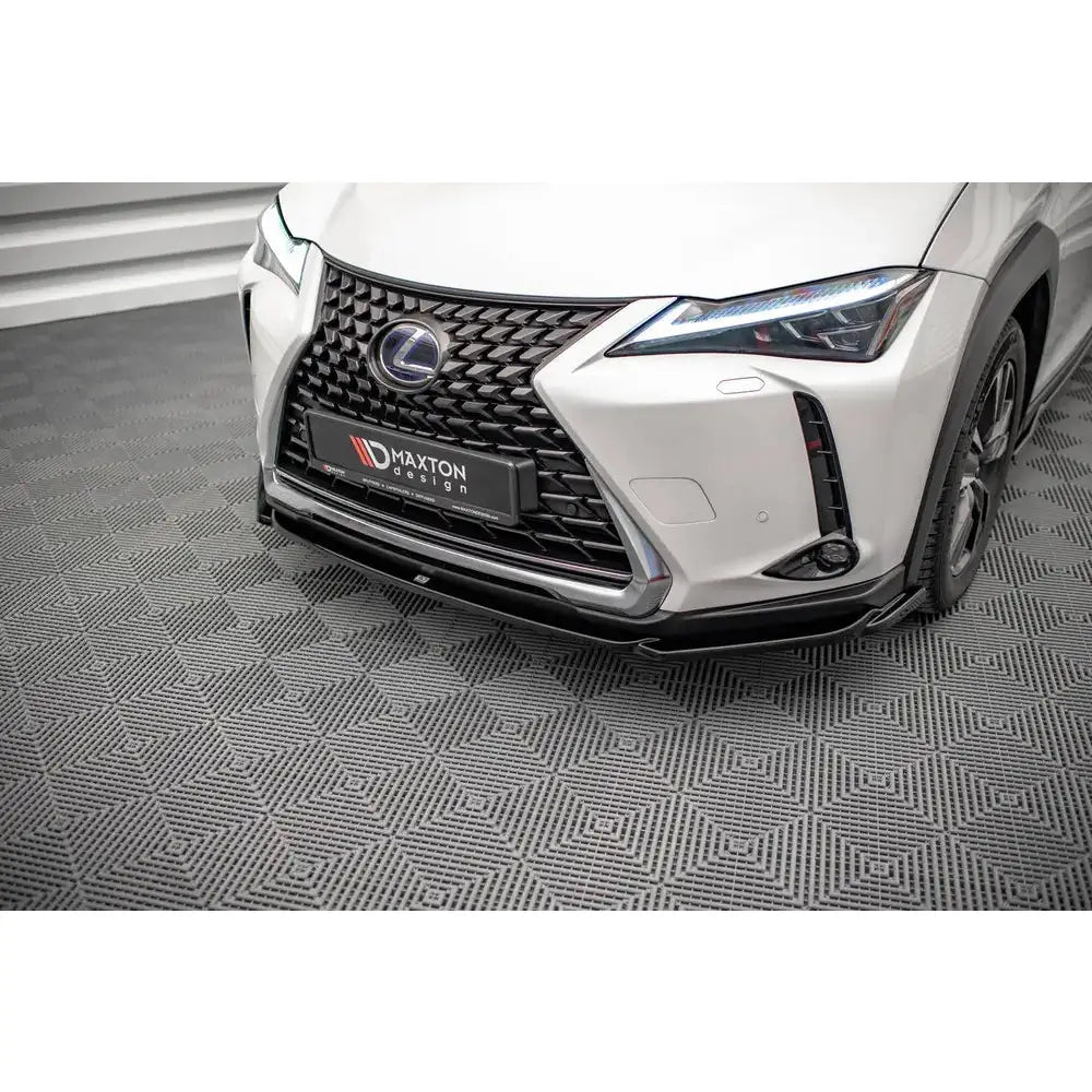 Spoiler på Lexus UX Mk1 med sort frontspoiler, karakteristisk grill og LED-lys i nærbilde.