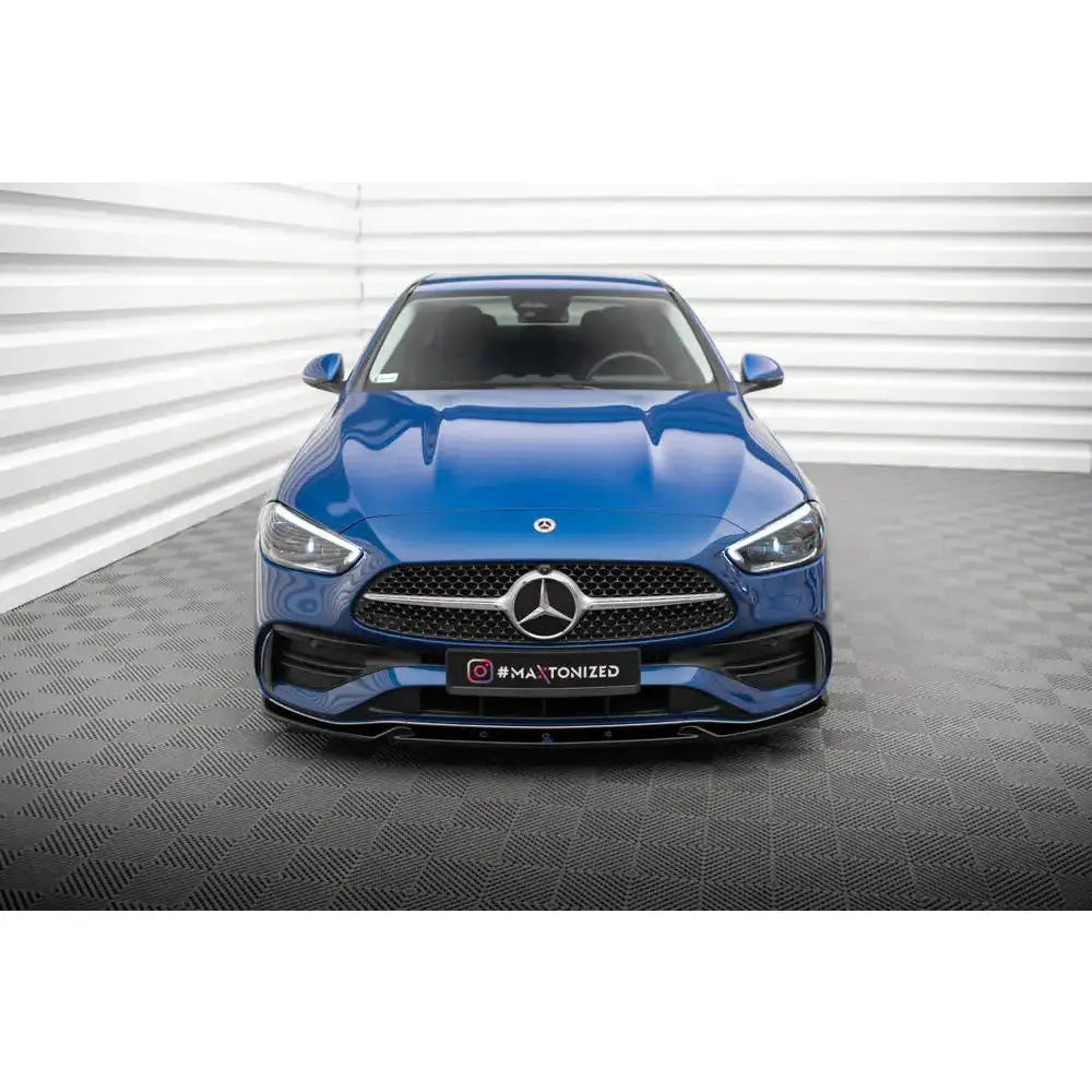 Frontspoiler på Mercedes C-Klasse W206 AMG-Line, blå bil sett forfra med sort grill og kromdetaljer.