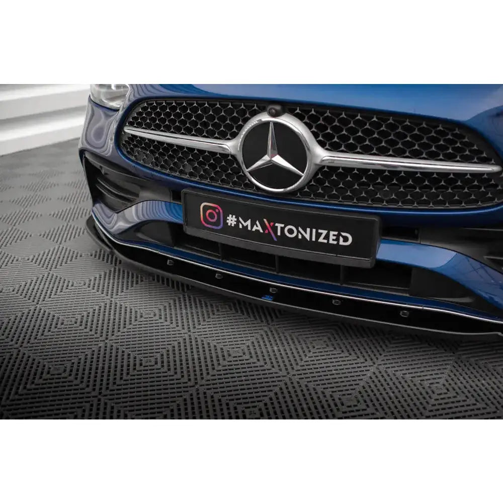 Spoiler på Mercedes C-Klasse W206 med svart frontsplitter og sølvgrill, sett fra siden.