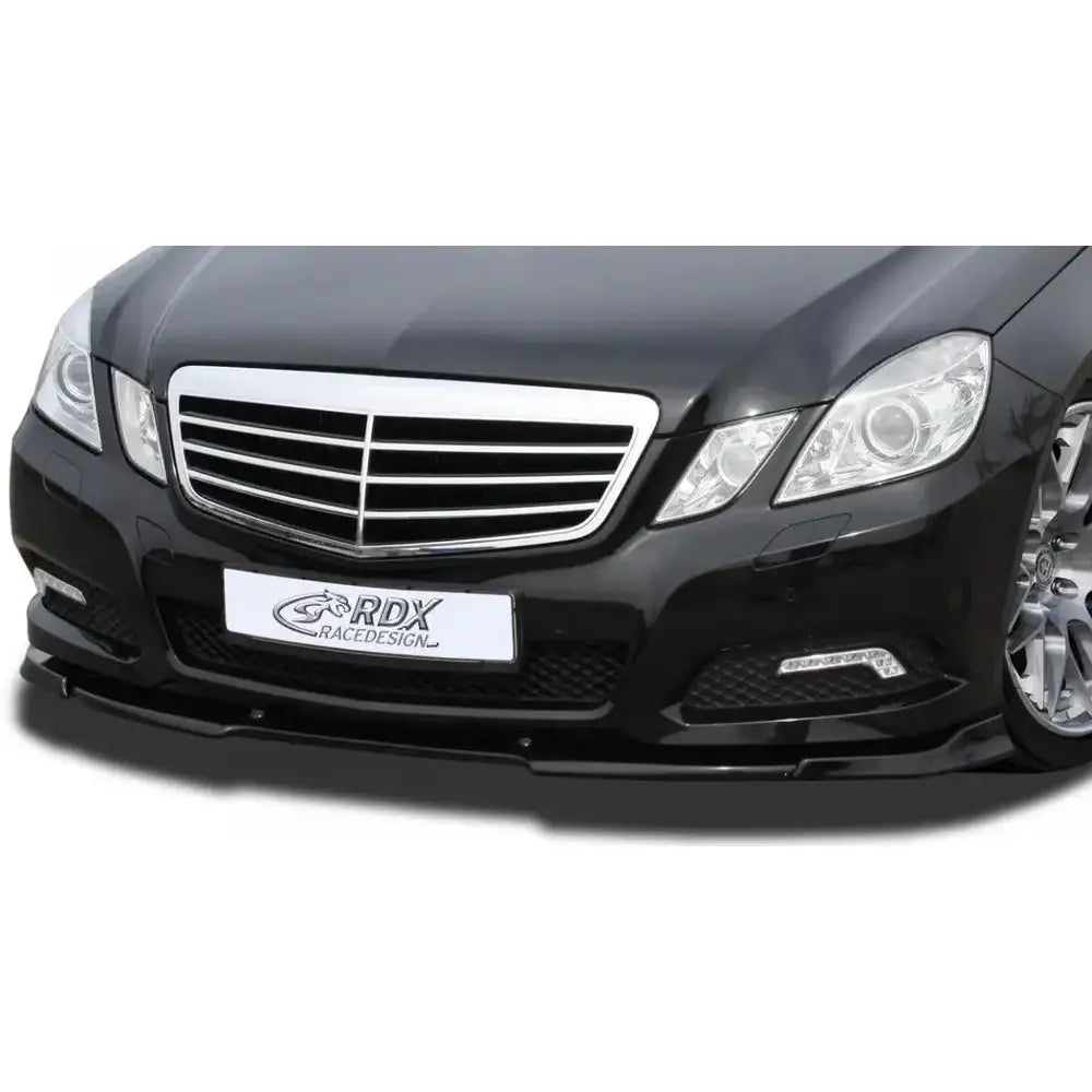 Frontspoiler til Mercedes E-Klasse W212 09-13 i svart plast under støtfanger, sett forfra med kromdetaljer.