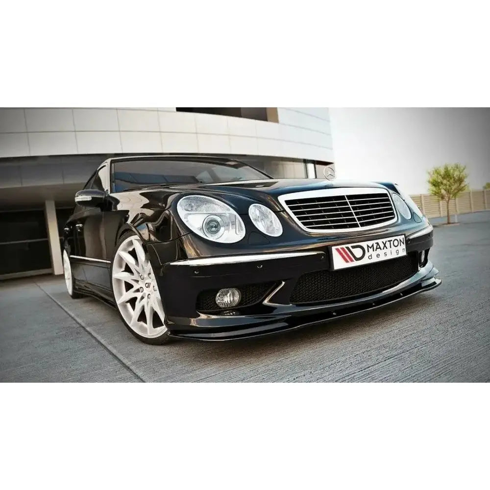 Frontleppe Mercedes E W211 Amg Preface montert på svart bil med store hvite felger og Maxton Design-logo.