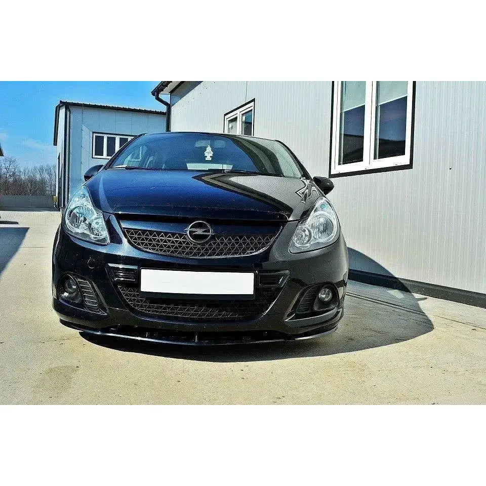 Spoiler til Opel Corsa D vist montert på sort bil med glanset finish foran et bygg.