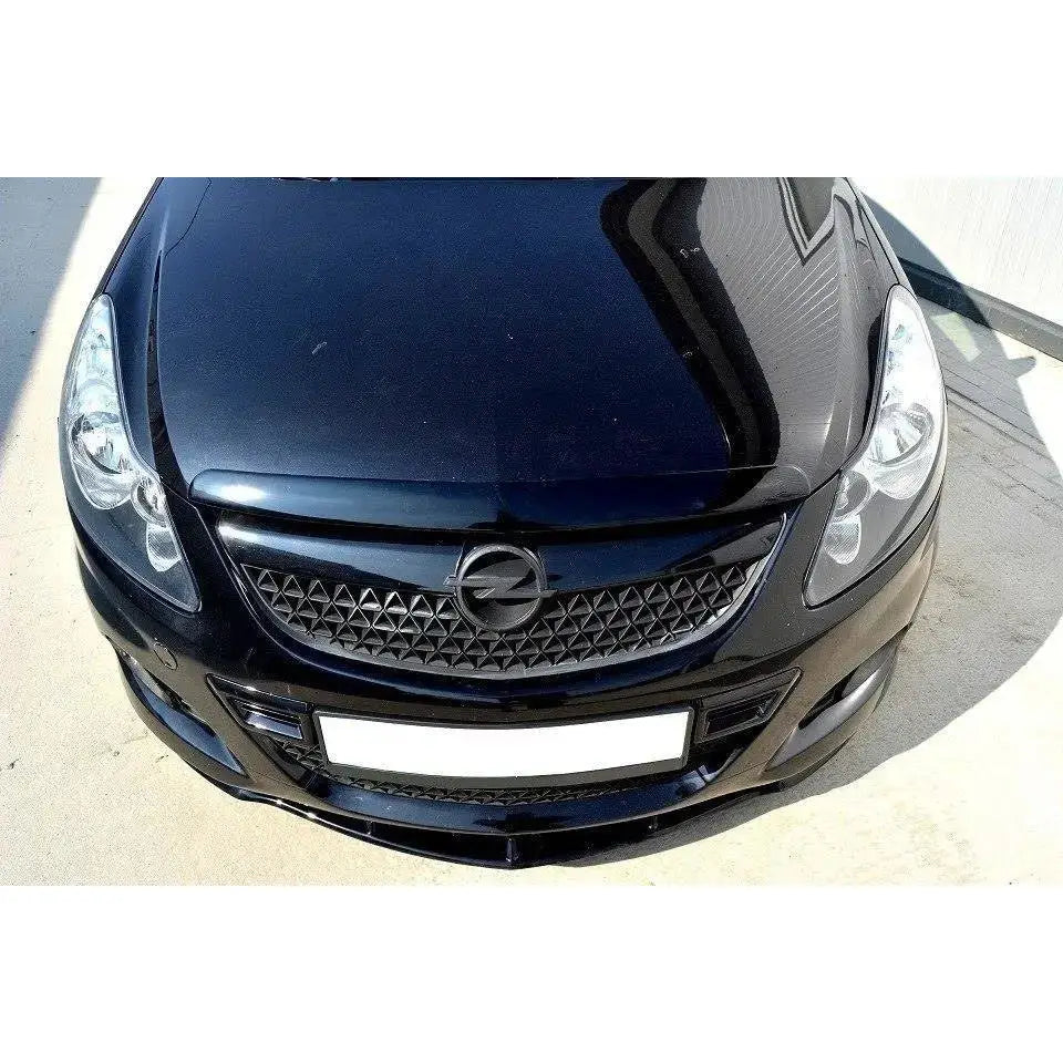 Front splitter for Opel Corsa D, sort design sett ovenfra med hovedlykter og mønstret grill.