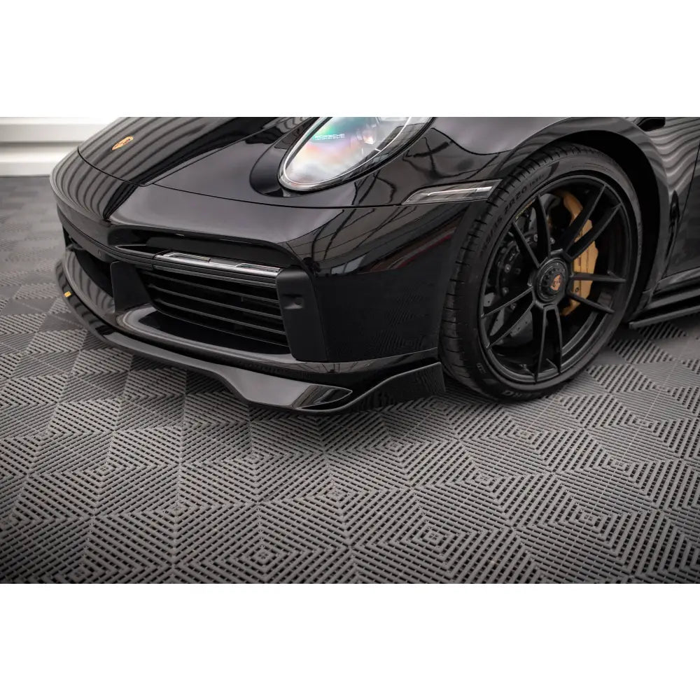 Front lip på Porsche 911 Turbo S 992 med karbonfiber-detaljer og sorte felger med gul bremsekaliper.