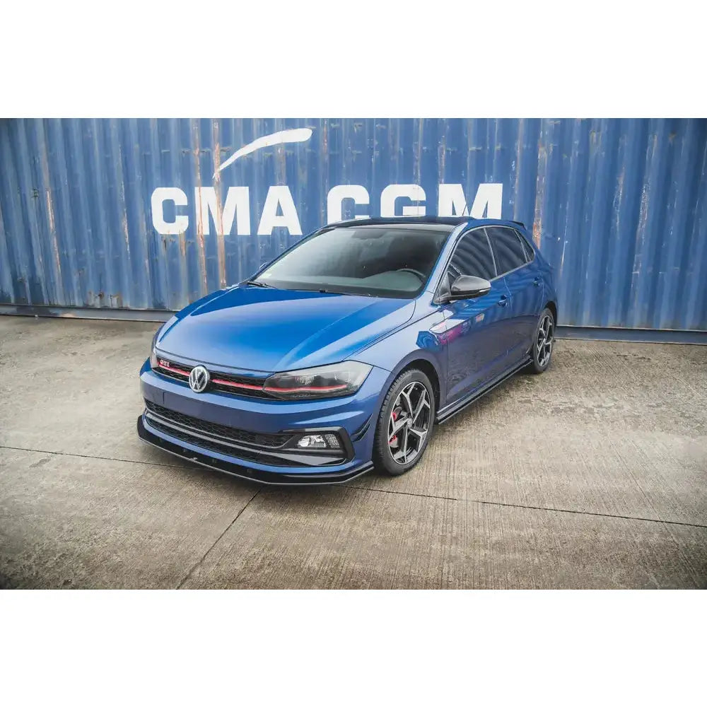 Frontspoiler på Volkswagen Polo GTI MK6 med svarte felger og røde detaljer foran blå container.