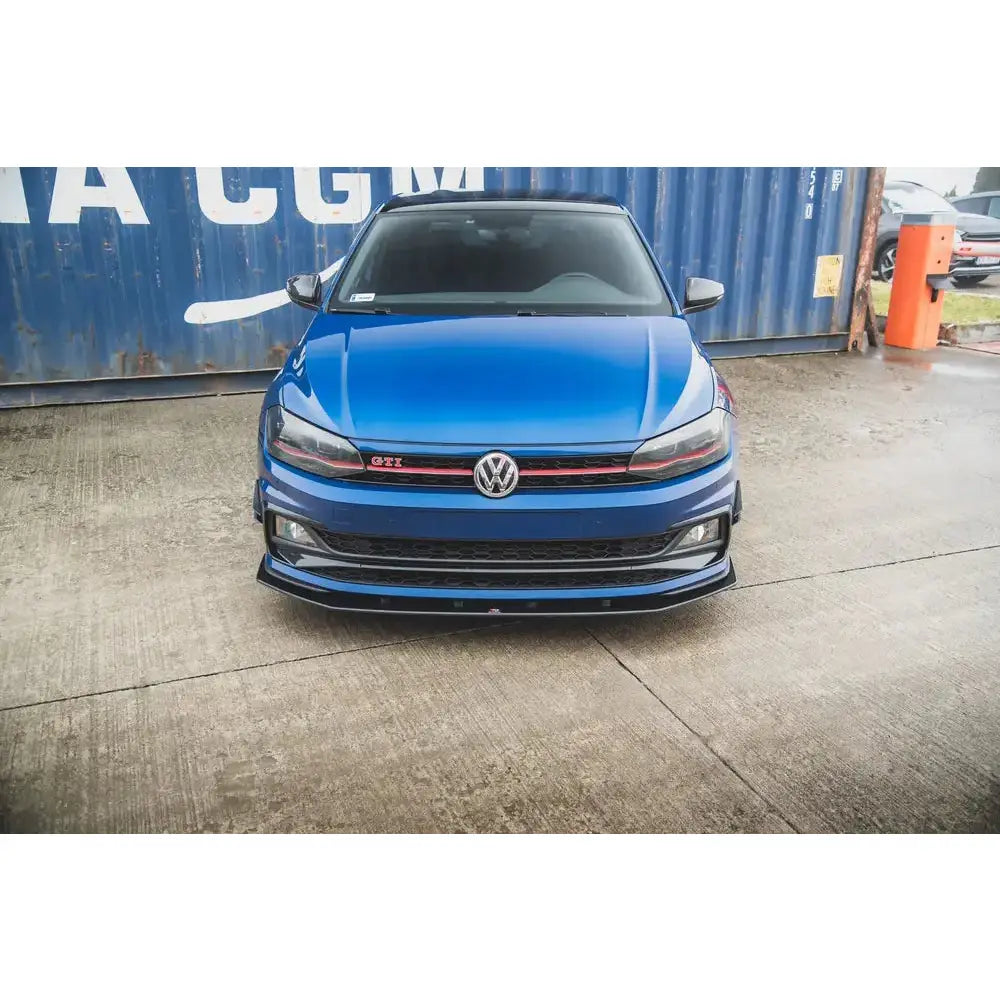 Spoiler på Volkswagen Polo GTI MK6, blå bil front med svarte og røde detaljer foran blå container.