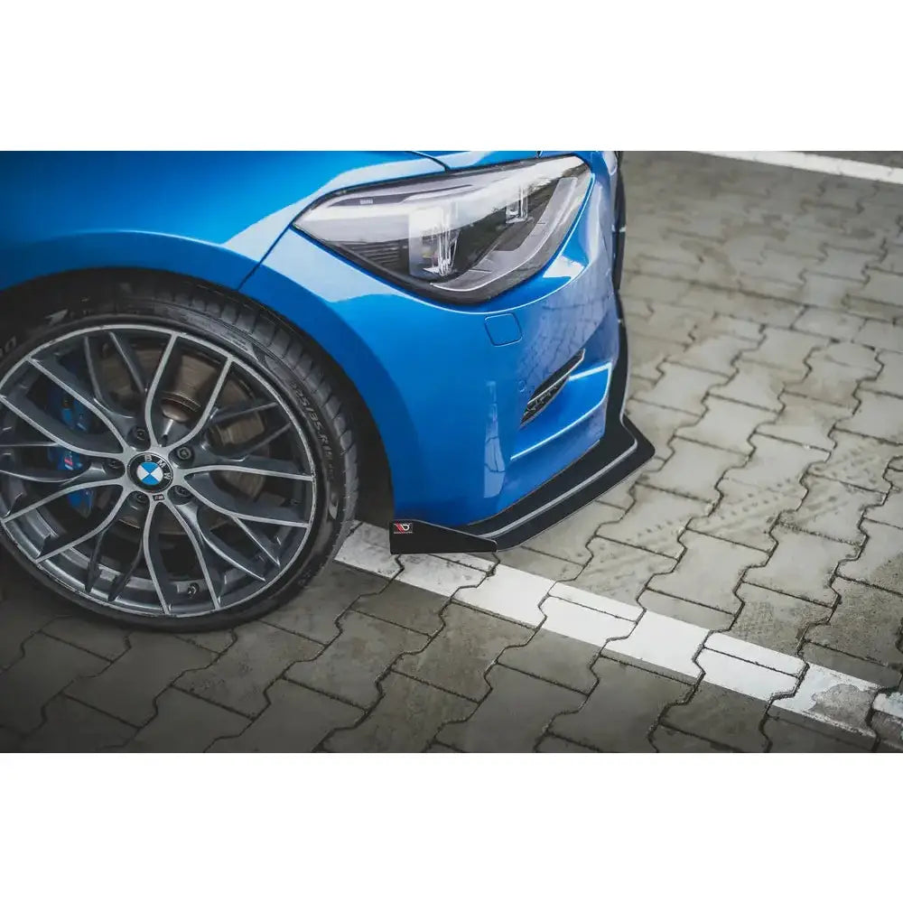 Front lip på BMW M135i F20 med svart frontspoiler og sølv aluminiumsfelg på brosteinsparkering.