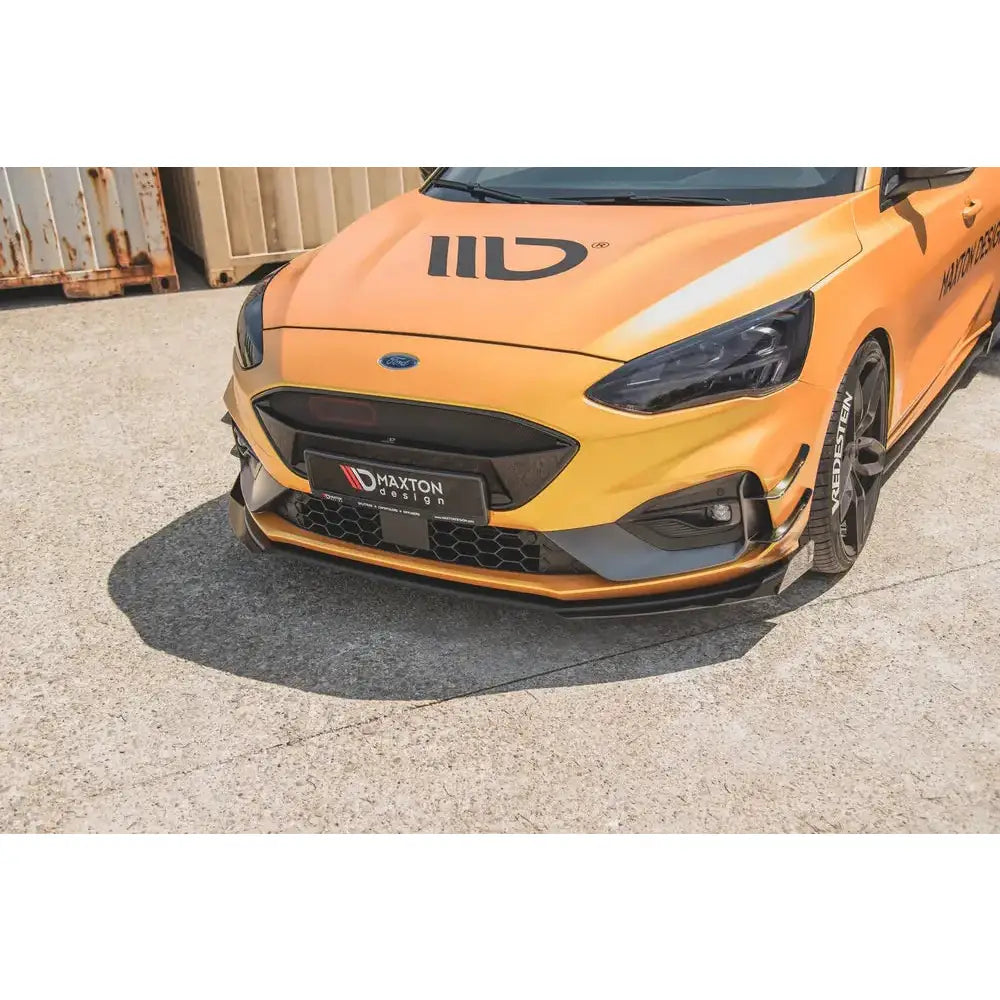 Front splitter på Ford Focus ST med sort spoiler, detaljerte lykter og Maxton Design-skilt synlig.
