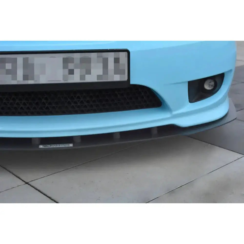 Frontspoiler Hyundai Tiburon Mk.2 Facelift Racing montert på lyseblå bil med sort grill og tåkelys.