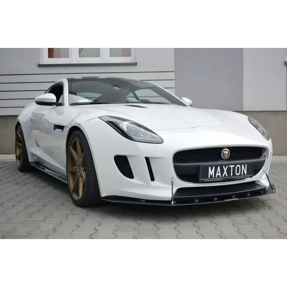 Frontleppe på Jaguar F-Type Racing, hvit sportsbil med sorte detaljer og bronsefargede felger utendørs.
