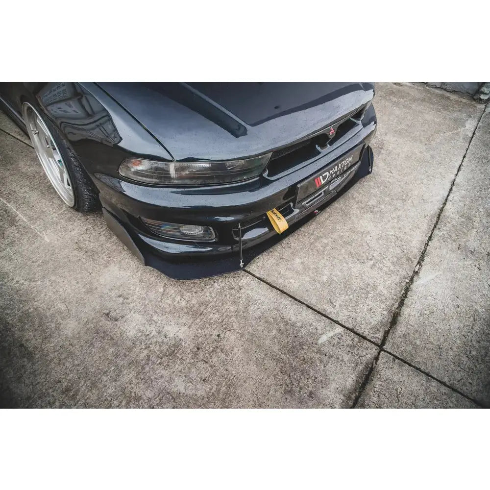 Frontspoiler til Mitsubishi Galant Avance Mk8 med sorte støttewirer og gul taustropp, sett skrått ovenfra.