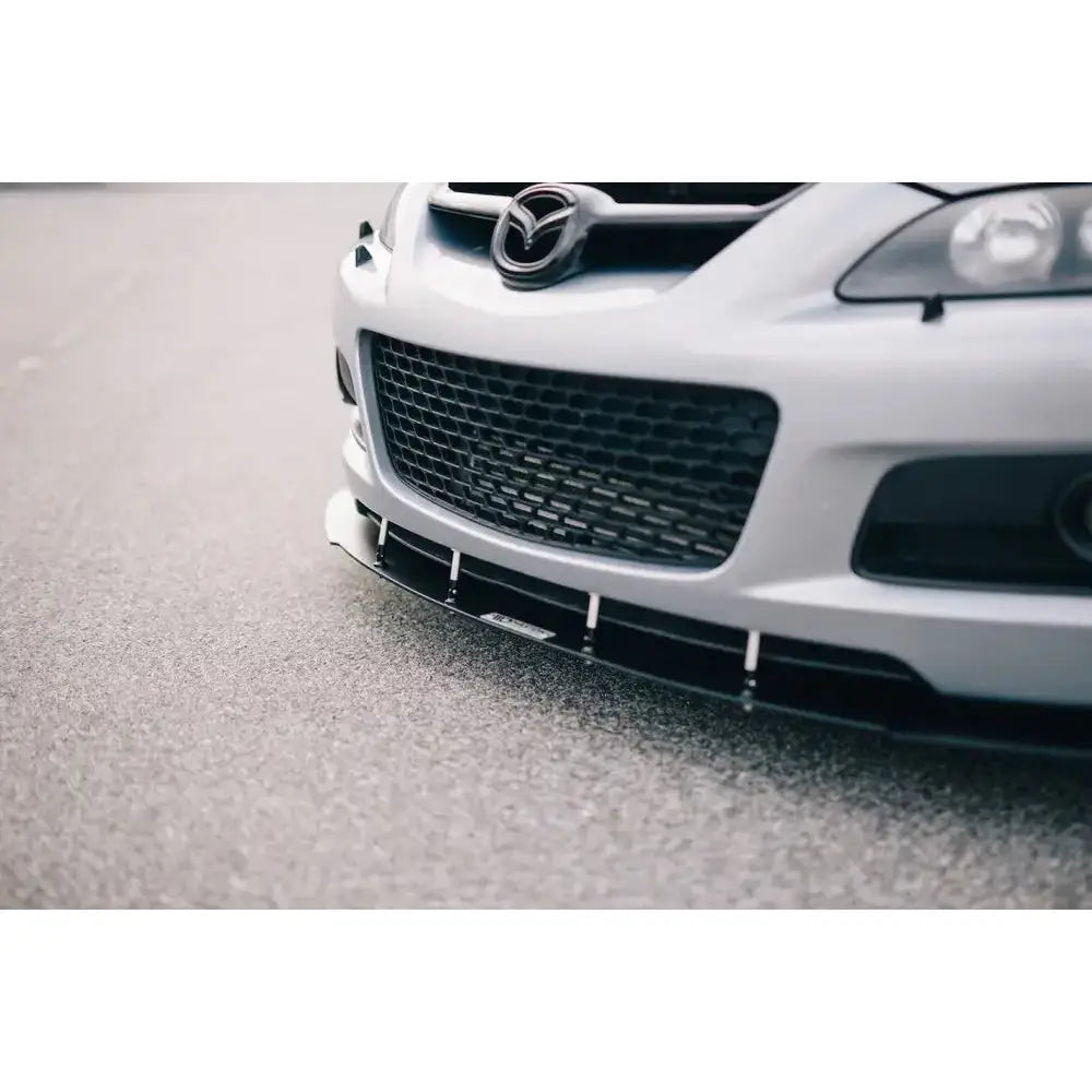 Spoiler Racing V.1 Mazda 6 Mk1 Mps montert foran på bil, nærbilde med svart grill og asfaltunderlag.