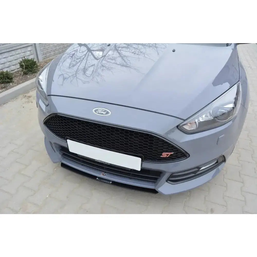 Front splitter på Ford Focus 3 ST Facelift med svart bikubemønstret grill og rødt ST-emblem.