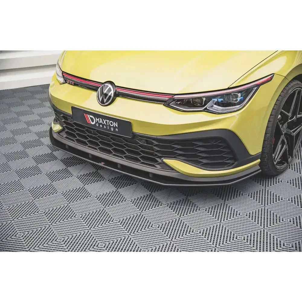 Spoiler til Volkswagen Golf 8 GTI Clubsport, nærbilde av gul front med svart grill og røde detaljer.