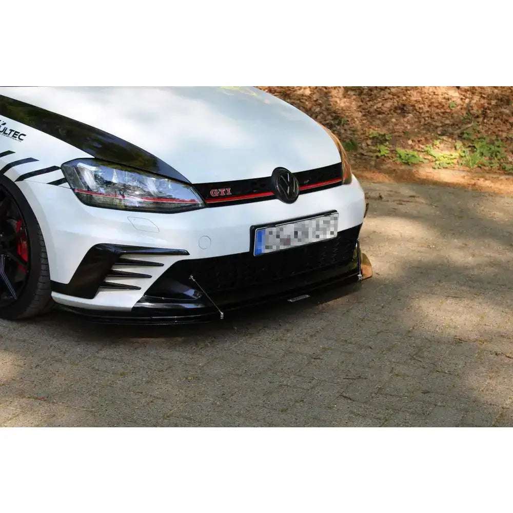 Frontleppe til VW Golf VII GTI Clubsport med svarte og røde detaljer, sett fra skrå vinkel på asfaltvei.