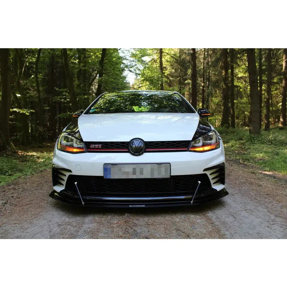Spoiler til VW Golf VII GTI Clubsport montert foran på hvit bil med røde detaljer, utendørs.