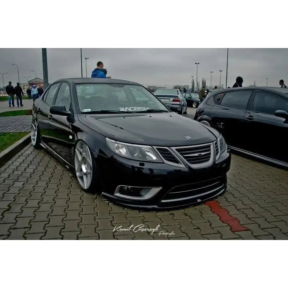 Front lip på Saab 9-3 Turbo X med senket understell og store sølvfelger, skrått forfra på parkeringsplass.