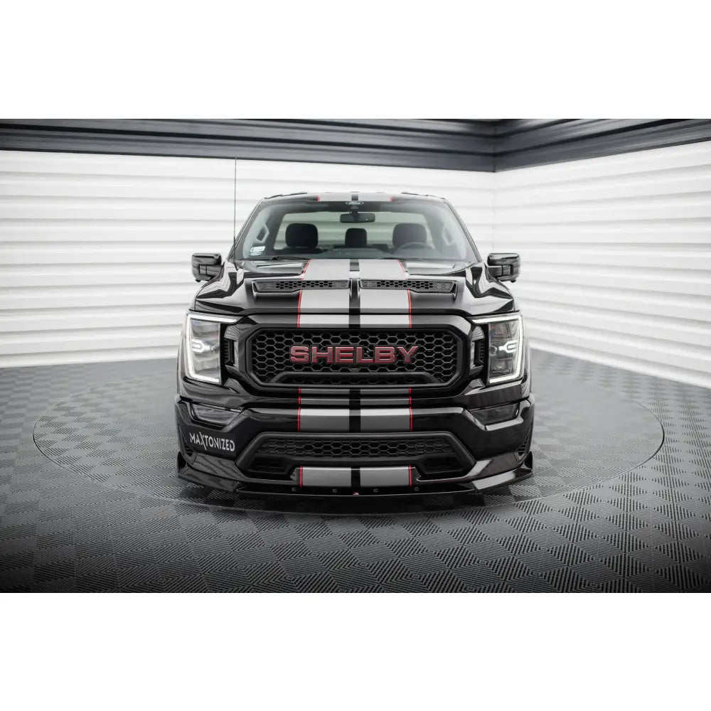 Front splitter på Shelby F150 Super Snake med grå og røde striper, rødt SHELBY-logo og moderne frontlys.