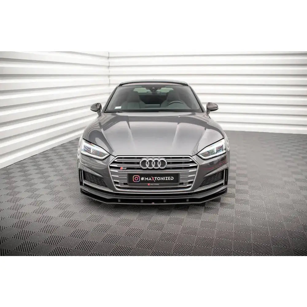 Frontspoiler på Audi A5 S-Line Coupé med markante LED-lykter og stor grill, sett forfra innendørs.
