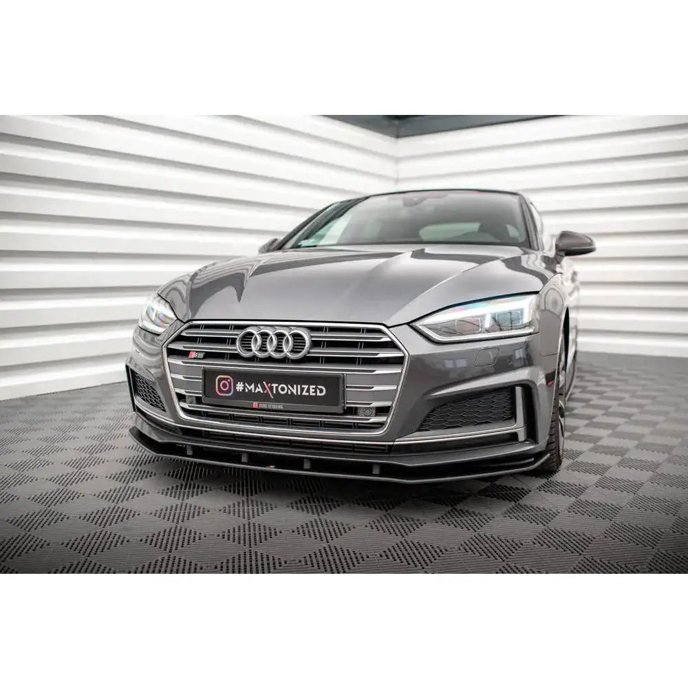 Front lip på Audi A5 S-Line med markante LED-lykter og kromdetaljer, sett skrått forfra innendørs.