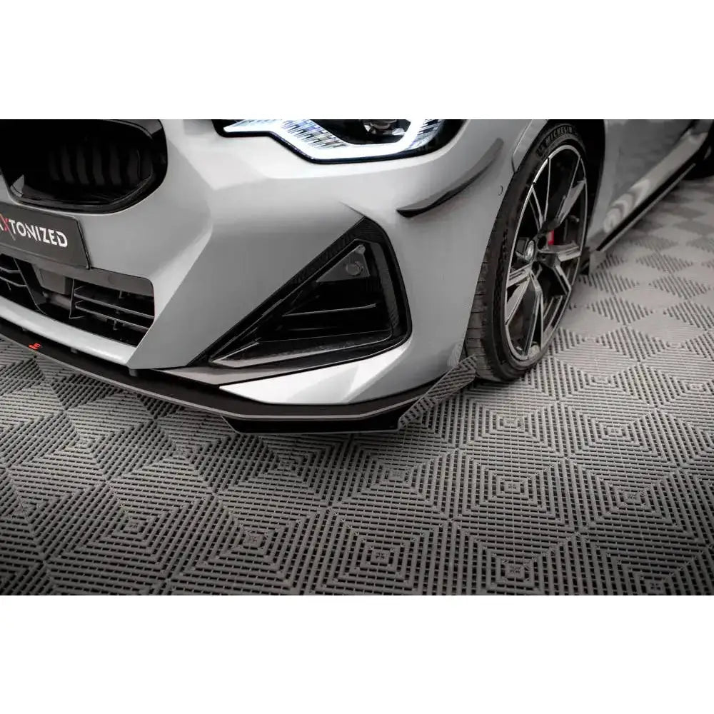 Front splitter på BMW 2 Serie Coupe M-Pack med markert spoiler og aluminiumsfelger på grått gulv.