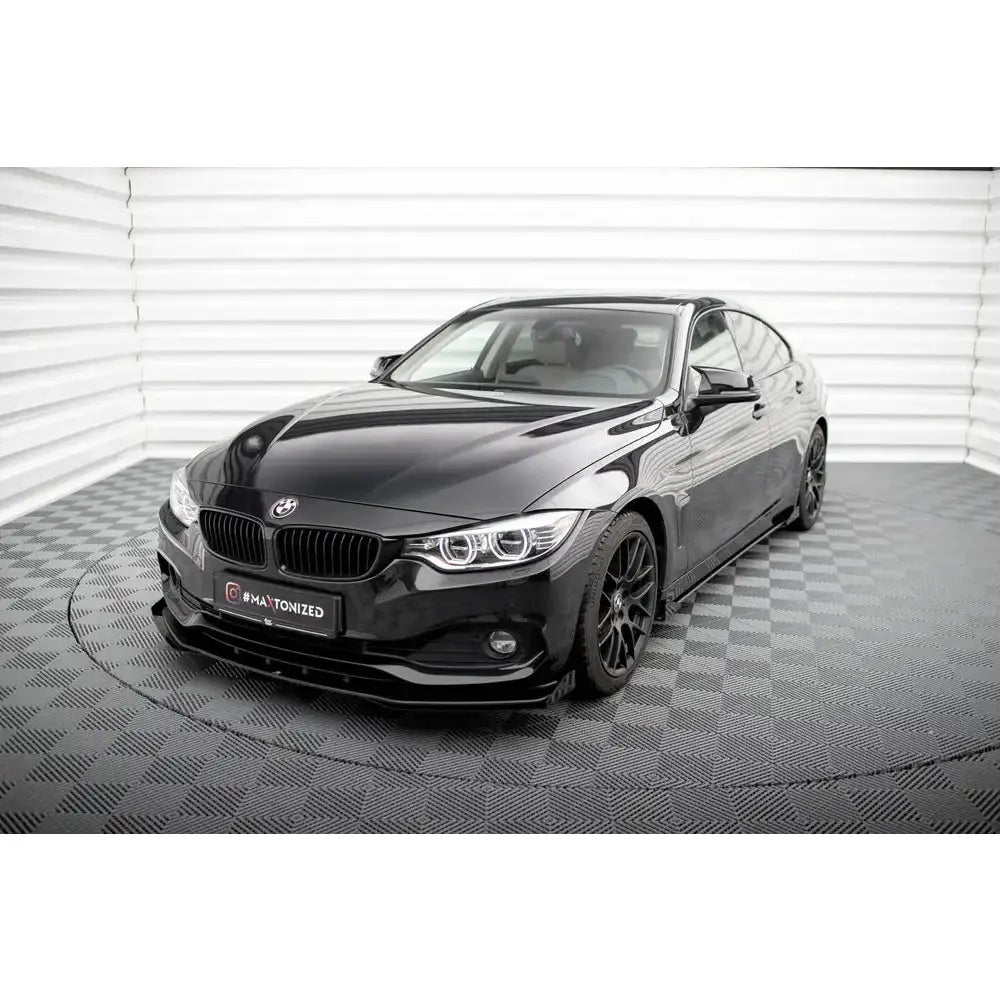 Frontspoiler Street Pro med flaps på sort BMW 4 Gran Coupe F36 sett skrått forfra innendørs.
