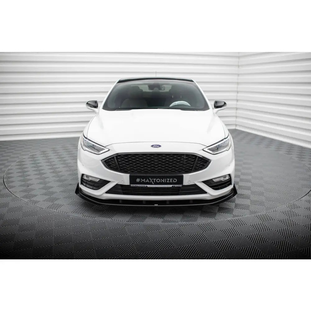 Front splitter på hvit Ford Mondeo Sport Mk5 Facelift sett rett forfra i lyst studio.