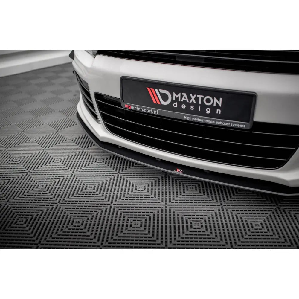 Front splitter Volkswagen Scirocco R Mk3 Street Pro montert på hvit bil med svart grill i showroom.