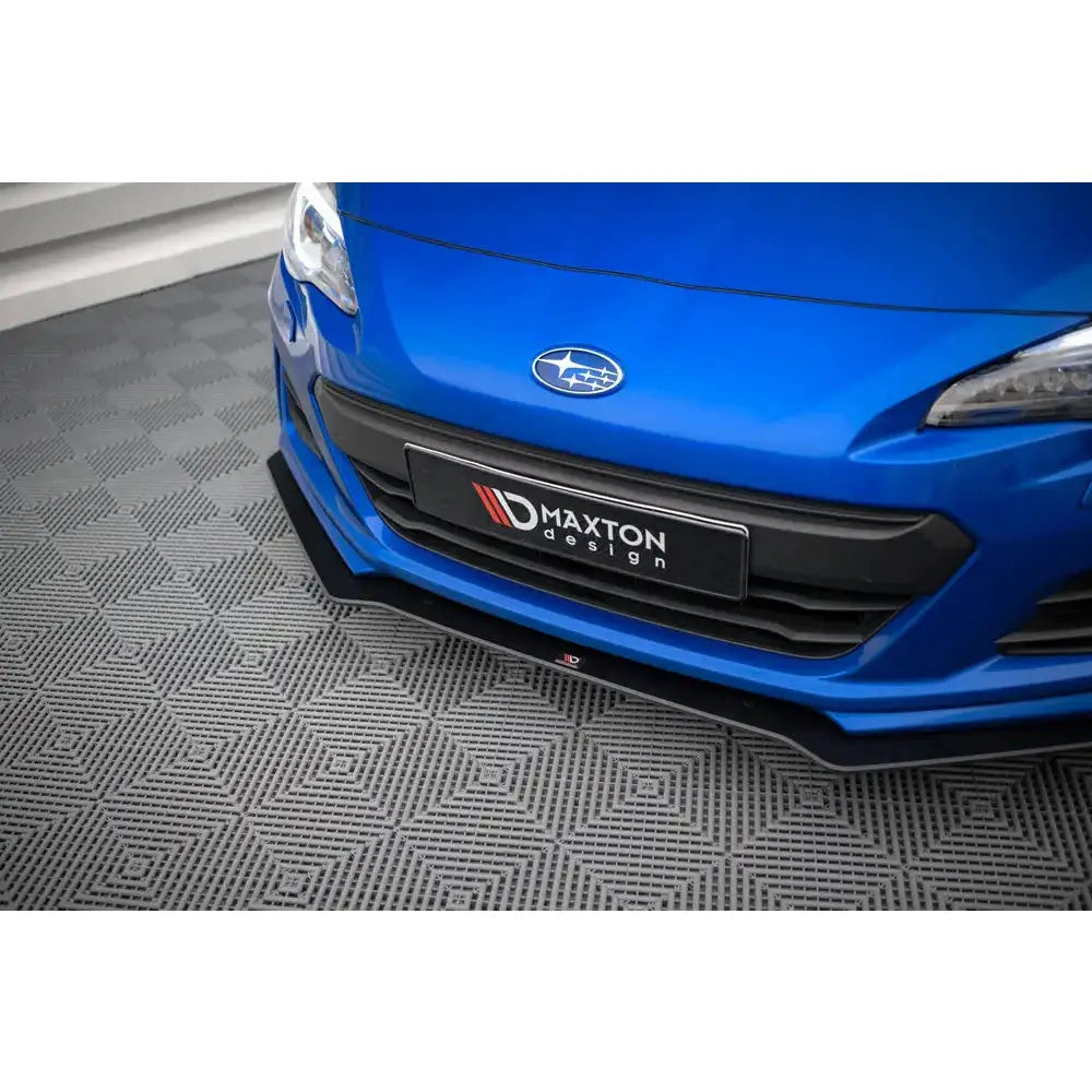 Front splitter på blå Subaru BRZ Mk1 Facelift med svarte detaljer, parkert på grått gulv med mønster.