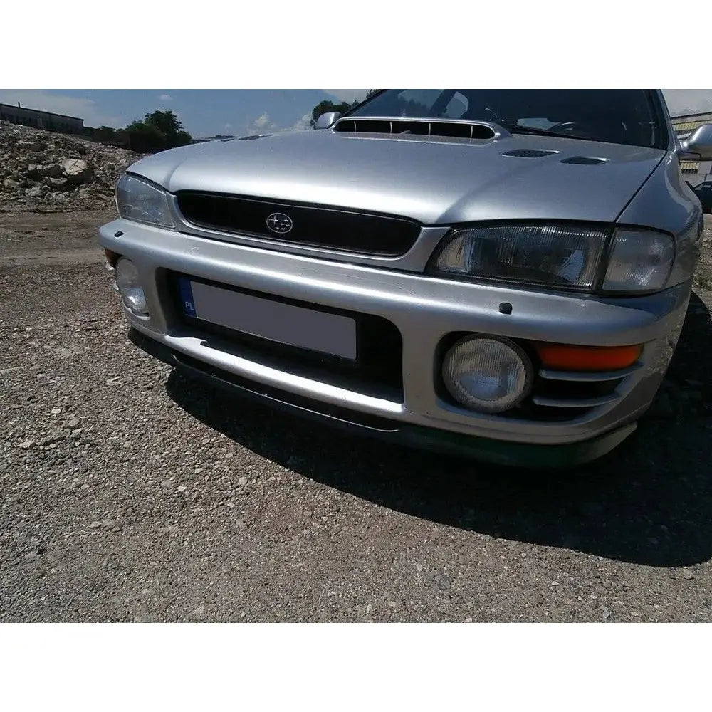 Spoiler Subaru Impreza GT sett skrått forfra med sølvfarget støtfanger, frontgrill og tåkelys utendørs.