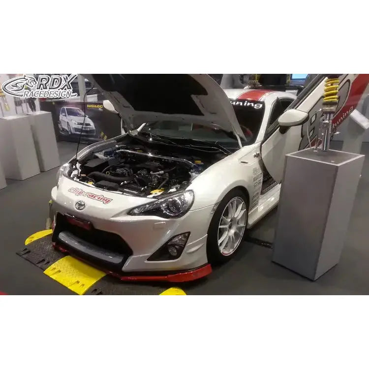 Frontspoiler Toyota GT86 Aero sett forfra i trekvart vinkel med åpent panser og dør på utstilling.