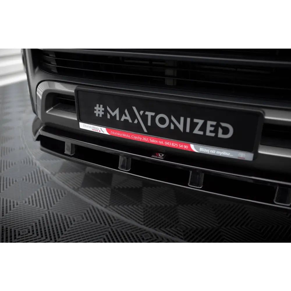 Front splitter til Toyota Hilux Invincible Mk8 Facelift, sort glanset plast, sett forfra med #MAXTONIZED-skilt.