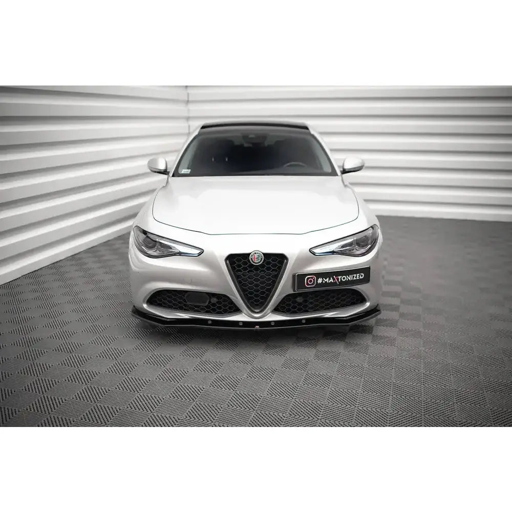 Frontleppe på Alfa Romeo Giulia V.1 Sport med sort spoiler foran, fotografert rett forfra på rutete gulv.
