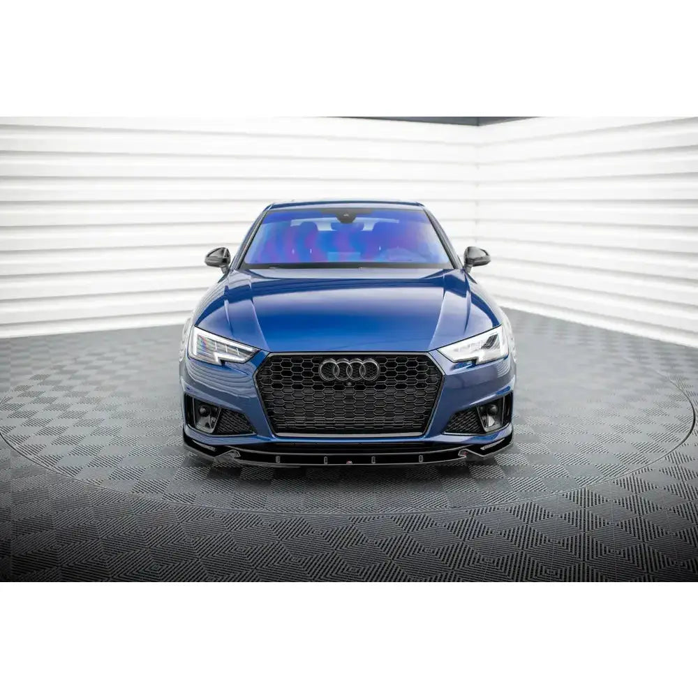 Frontleppe på Audi A4 B9 V.1 Competition, mørkeblå bil med sort grill i lyst showroom.