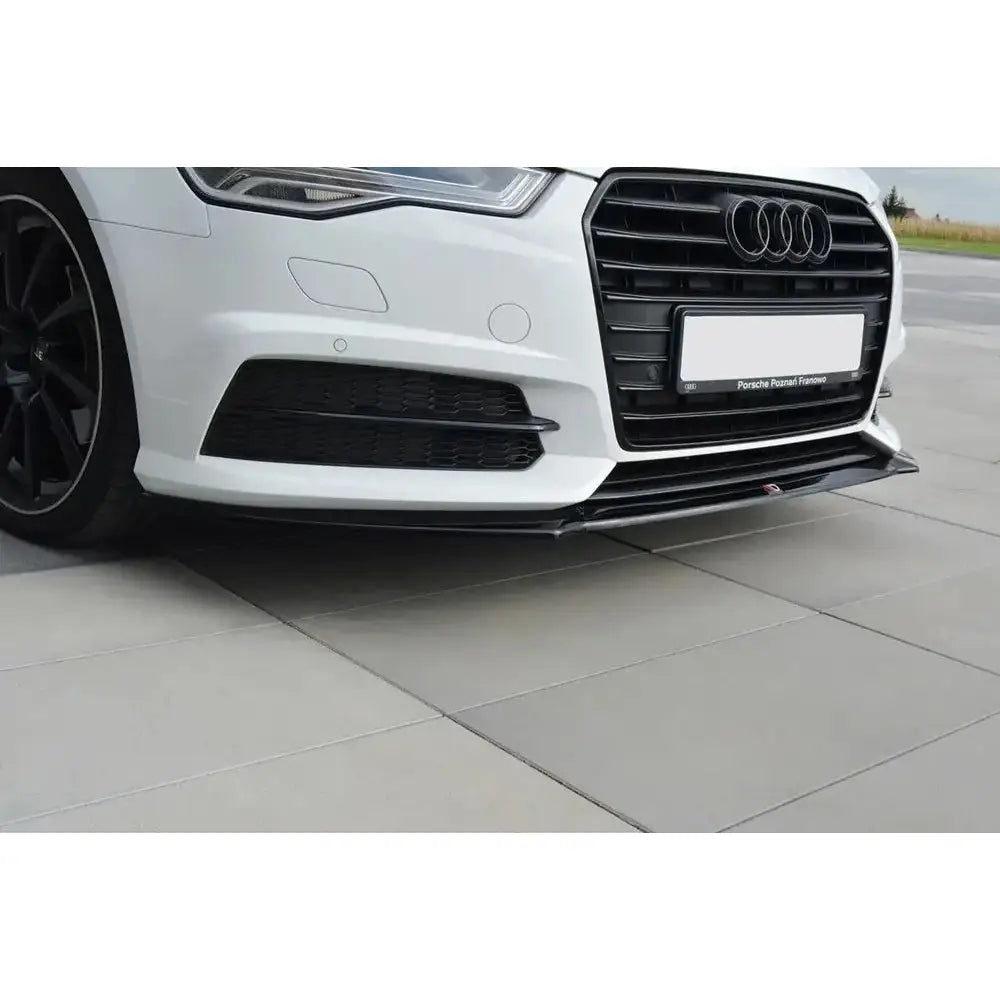 Front splitter på sort frontleppe til Audi A6 C7 S-Line, montert på hvit bil med synlig grill og tåkelysdeksel.