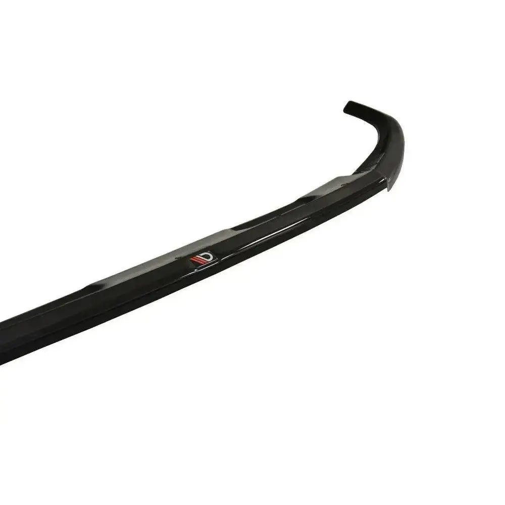 Front lip Audi Q2 Mk1 V.1 i svart glanset plast med logo, sett skrått ovenfra mot hvit bakgrunn.