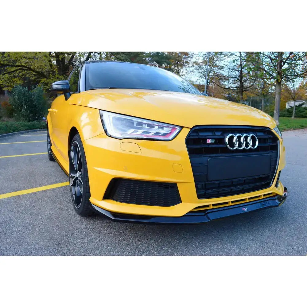 Frontspoiler Audi S1 Mk1 V.1 på gul bil med svart grill, sportslige detaljer og S1-logo foran.