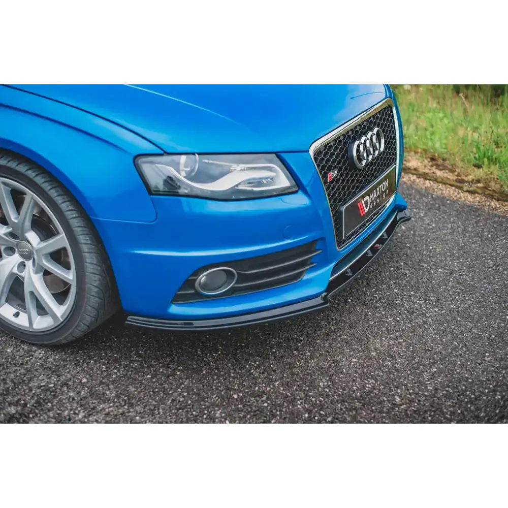 Front lip på blå Audi S4 med svart splitter, detaljerte frontlykter og aluminiumsfelg på asfalt.
