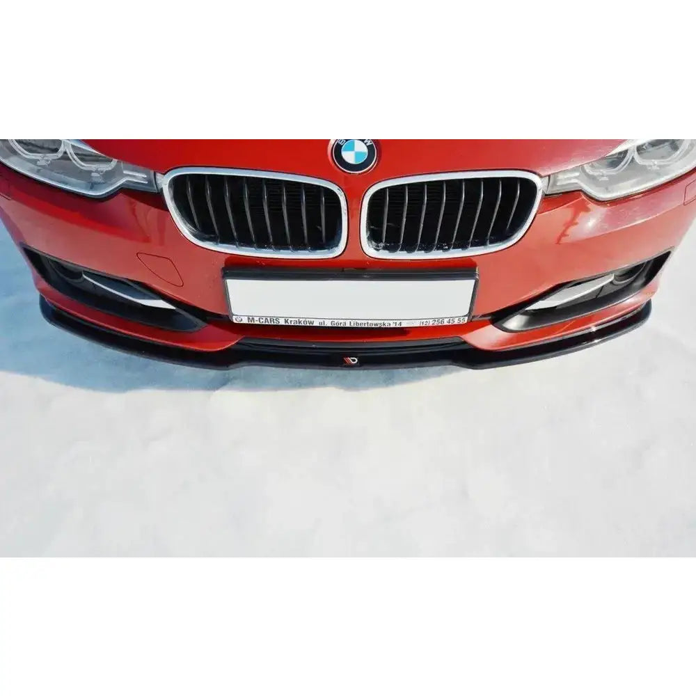 Frontleppe til BMW 3 F30 V.1, sort spoiler montert under rød bils frontstøtfanger.