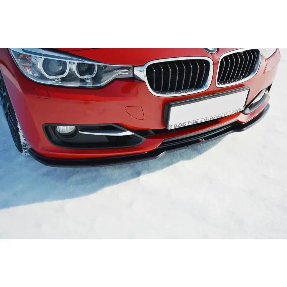 Front splitter på sort frontspoiler til BMW 3 F30 V.1 montert under rød støtfanger på snø.