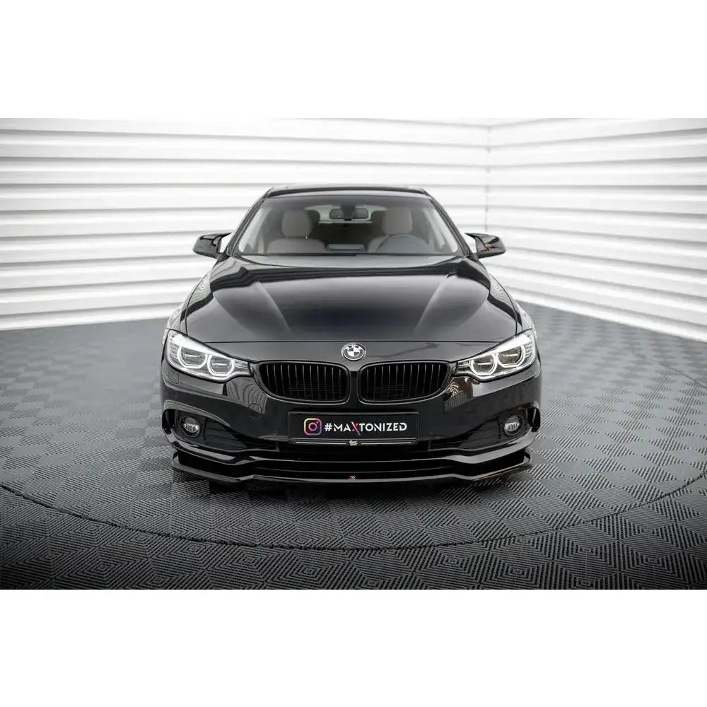 Spoiler på BMW 4 Gran Coupe F36 V.1 sett forfra med LED-frontlykter mot lys, riflet vegg.
