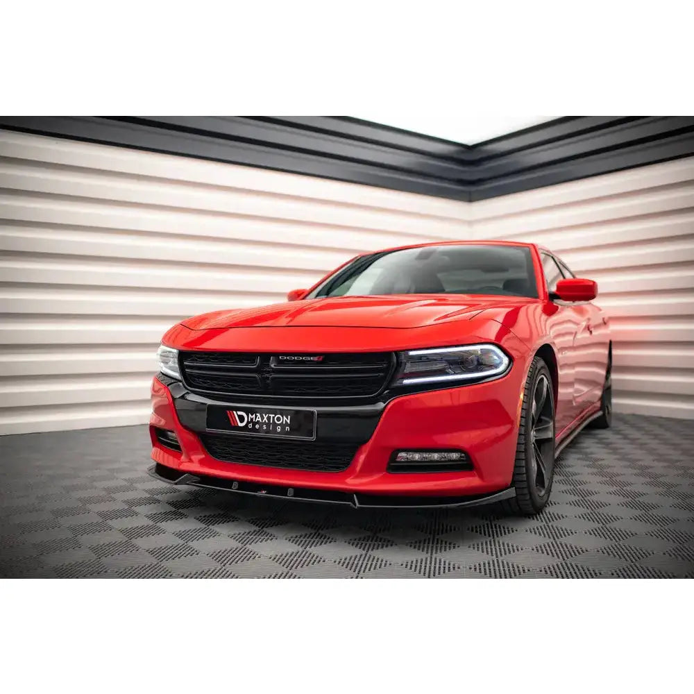 Front splitter på rød Dodge Charger RT Mk7 Facelift med sort grill og svarte felger i showroom.