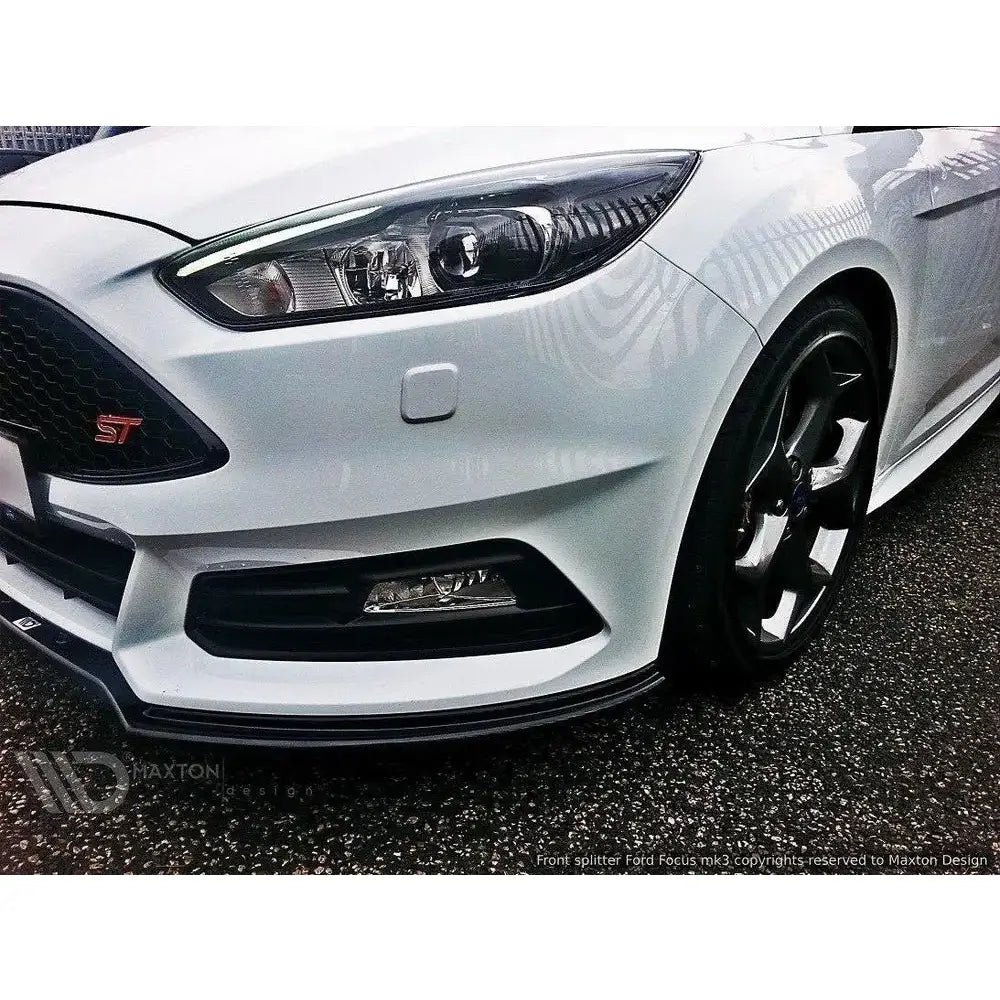 Spoiler på Ford Focus ST Mk3 Facelift med sort frontsplitter, ST-logo og sorte felger utendørs.