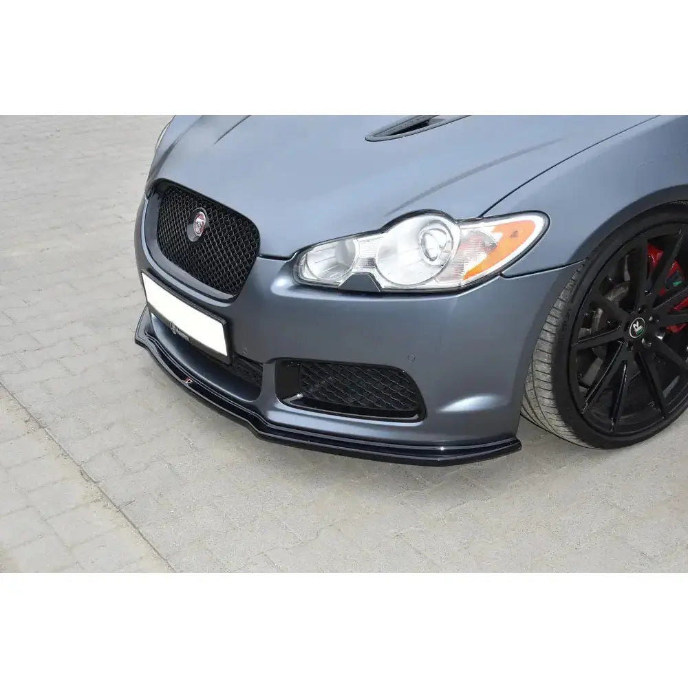 Front splitter på Jaguar Xf-R V.1, nærbilde av sort hekkspoiler under grå bilfront med grill og frontlys.