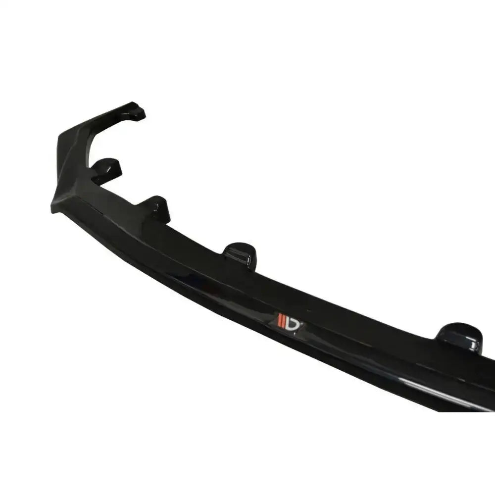 Frontspoiler til Lexus Rc F V.1 i sort, skinnende plast med små fester og synlig logo, nærbilde fra skrå vinkel.