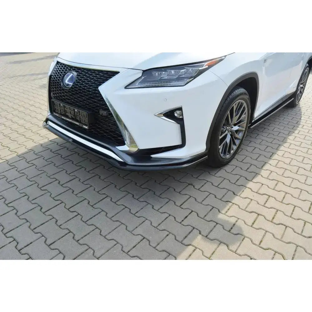 Spoiler til Lexus RX Mk4 V.1 F-Sport i sort plast og metall sett forfra på hvit bil på brostein.