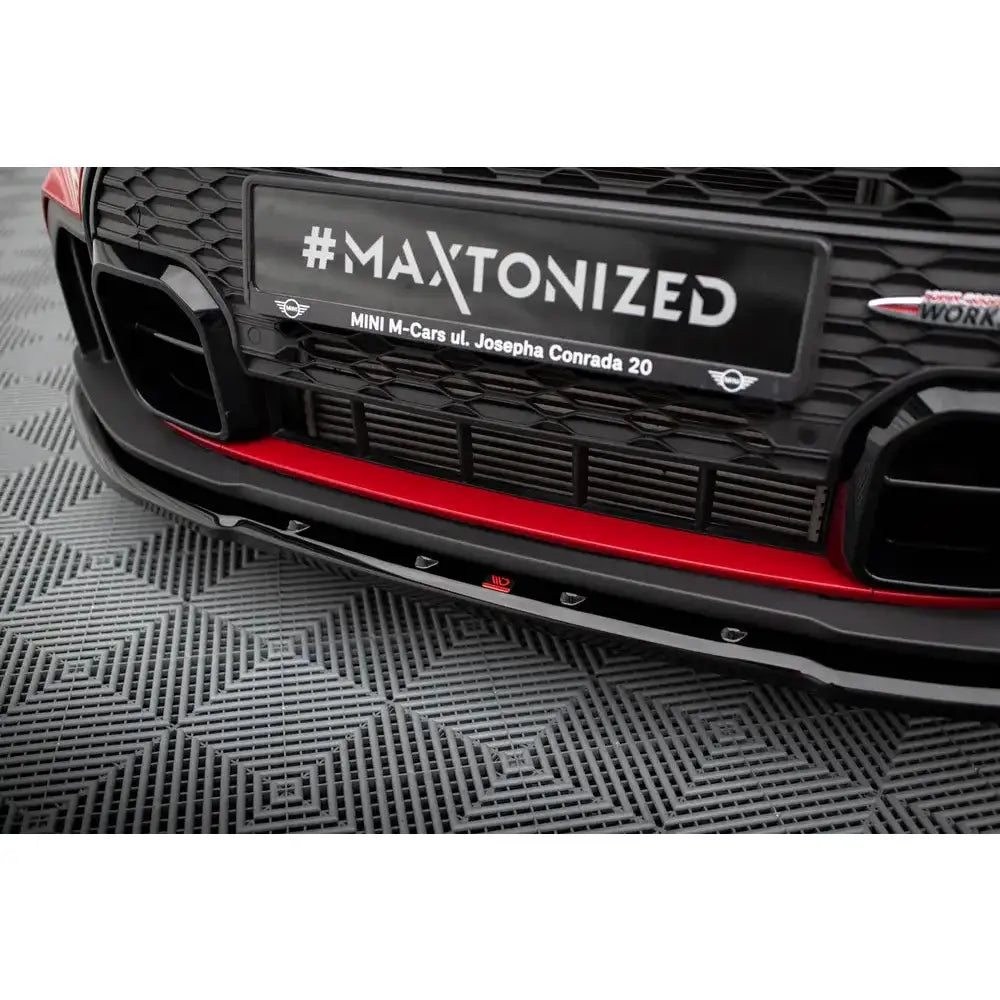 Spoiler til Mini Cooper S JCW F56 Facelift V.1 med sort og rød detalj, synlig grill og blank frontsplitter.