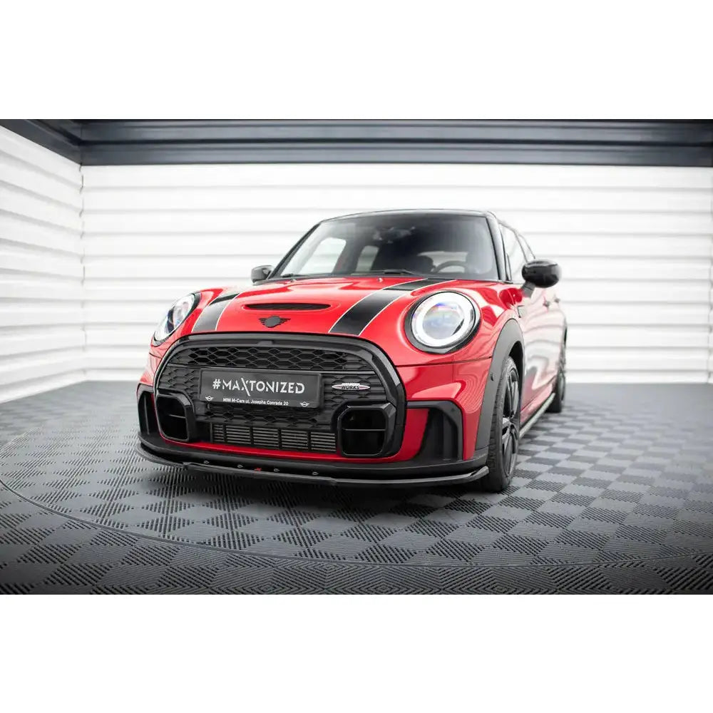 Front splitter på rød Mini Cooper S John Cooper Works F56 med svarte striper, sett forfra i lyst rom.