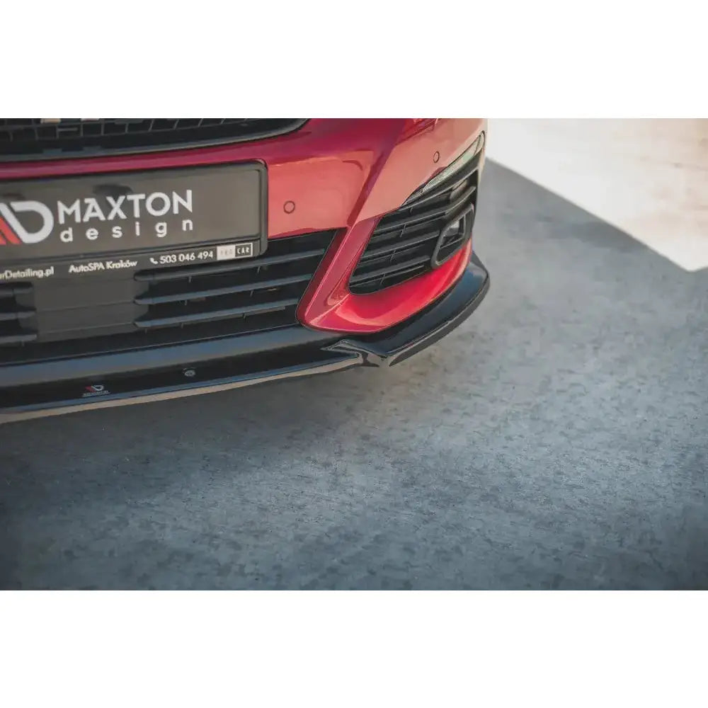 Front lip på Peugeot 308 GT Mk2 Facelift V.1, sort plastspoiler sett fra skrå vinkel på rød bil.